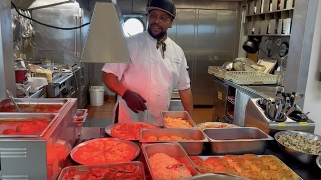 The Point Sur research vessel chef posing with a meal they prepared. 