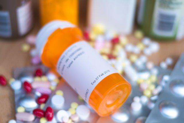 Pile of various expired prescription medicines and bottle focused on expired date. Antibiotic , paracetamol, vitamins drugs.