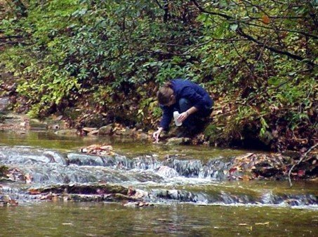 A photo of a researcher taking water samples.