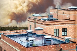 Wildfire approaching a building with HVAC units on top