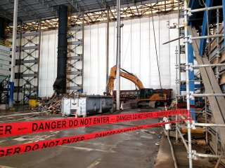 Interior of Segment 3 building with construction equipment, scaffold, danger warning tape.
