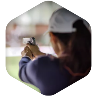 woman at firing range with focus on firearm