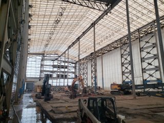 Interior of Building 3 focusing on white, translucent roof and construction equipment