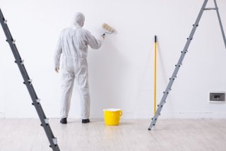 Person painting with disposable coveralls on