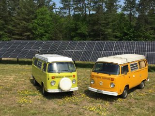 Volkswagen vans in front of solar panels (photo credit Grandy Oats)