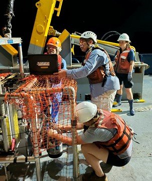 Workers on deck transferring images from SPI-PV to a laptop