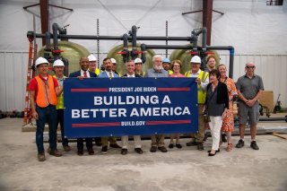 People holding a sign that says 'Building a Better America'