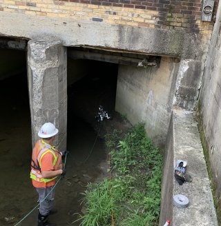 Workers using a rover in the culvert along Sulphur Run