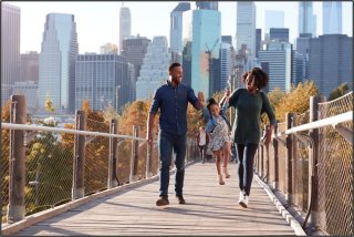 Family crossing bridge into the city