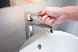 a person using a faucet handle